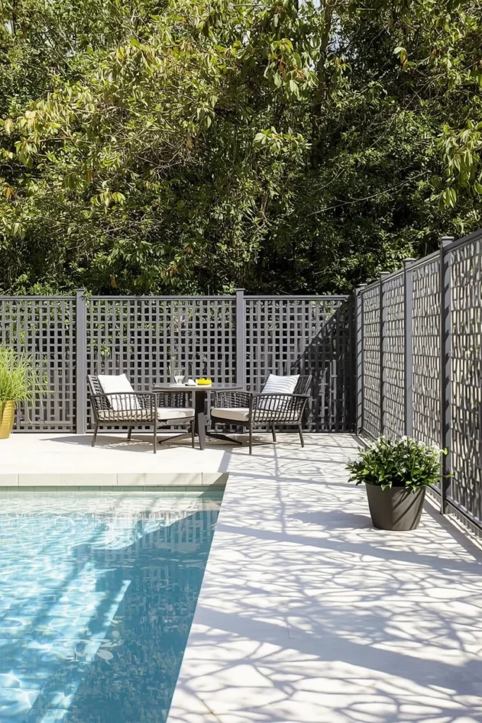 Laser-cut metal privacy screen beside modern pool